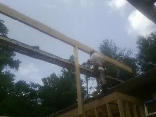 Carpenter setting a ridge beam over a new addition frame — Ice Dam Removal by Roofing Brothers in Roachdale