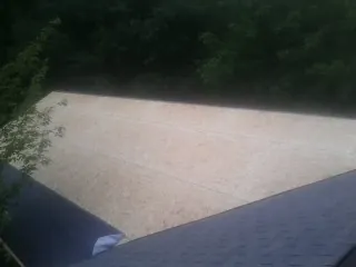 New OSB roof sheathing installed beside an existing shingle roof in Roachdale