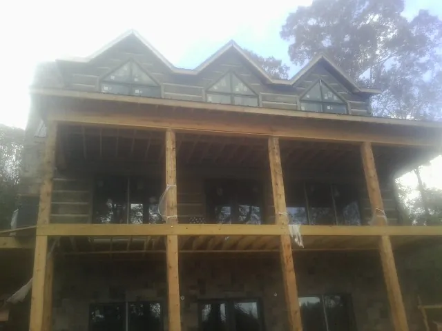 Dormers and porch framing on a large log home under construction — Roof Coating work by our crew in Roachdale