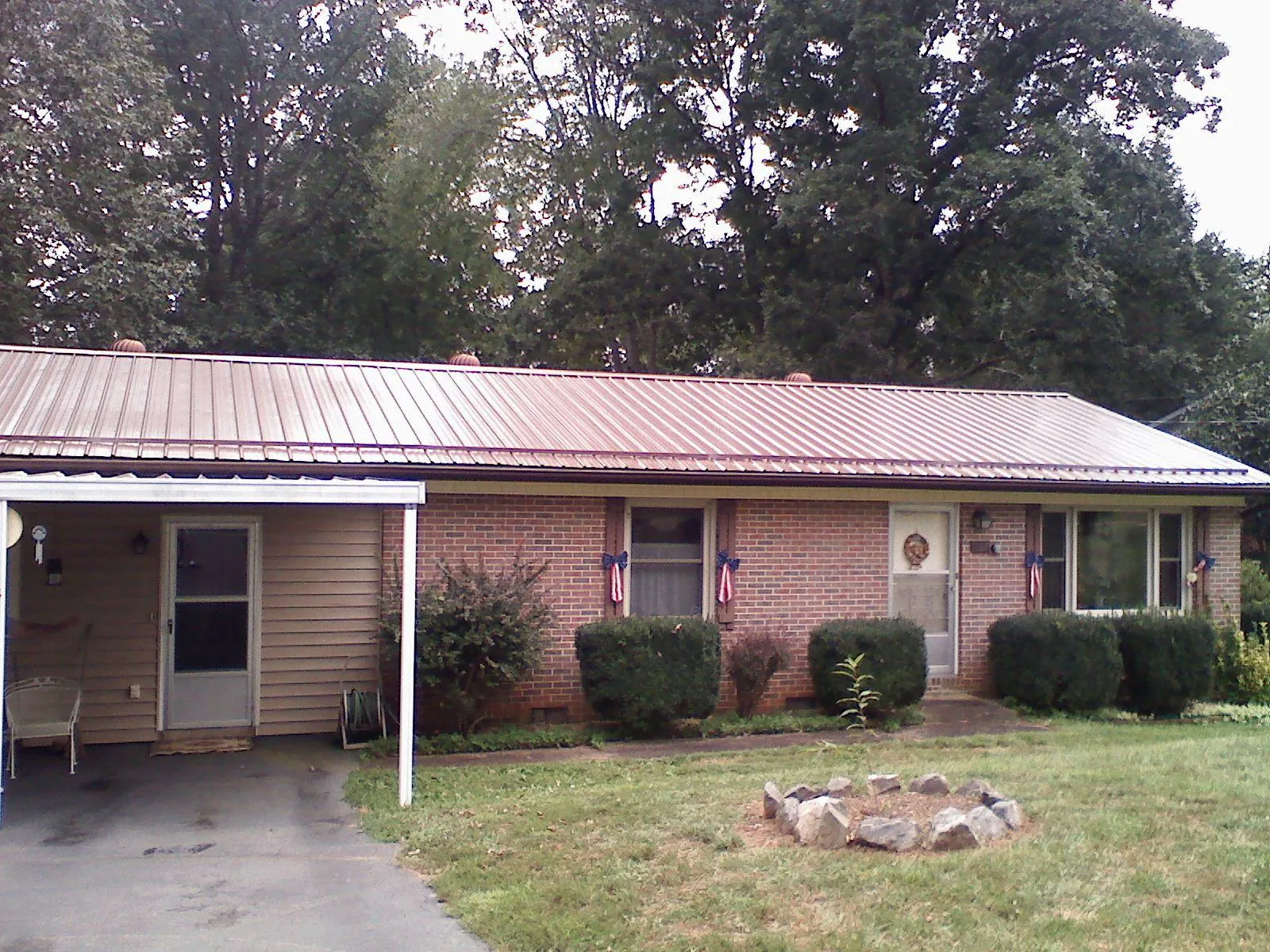 Bronze metal roof and carport on a brick ranch home — Roof Repair work by our crew in Roachdale